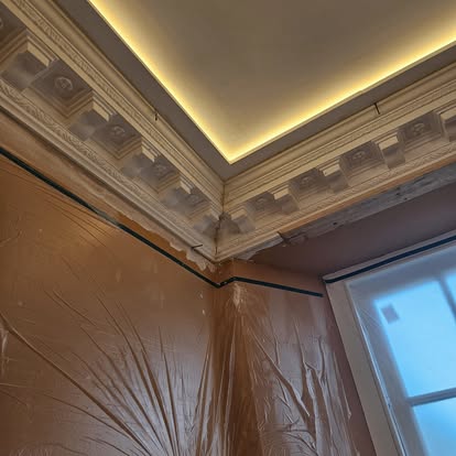 Ornate corner cornice and ceiling lighting during installation