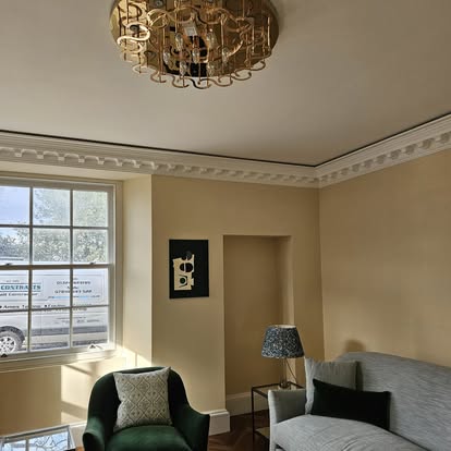 A living room with decorative white cornice and a finished ceiling, from the JMG Contracts portfolio